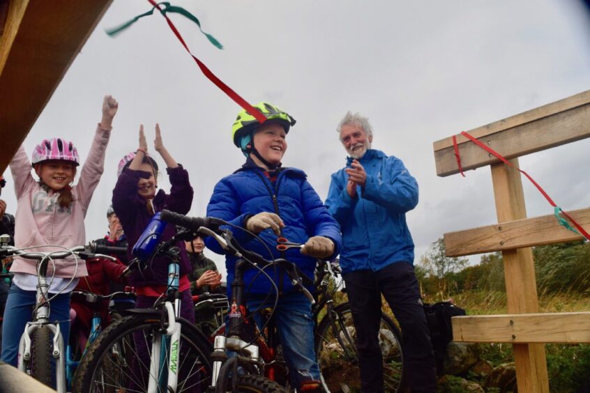 Len Seal applauding as young children prepare to set off on bicycles