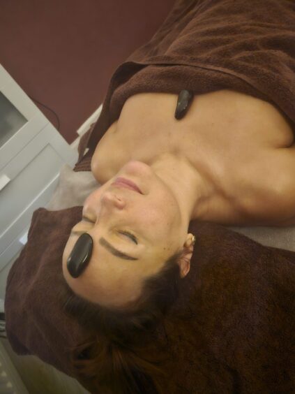 woman enjoys hot stone massage at Charm Spa for Valentine's Day 2025