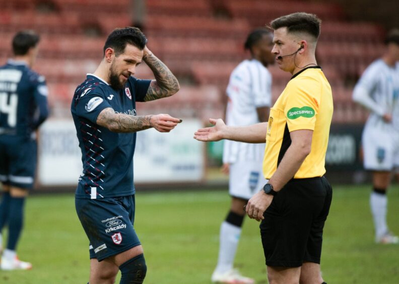 Dylan Easton hands over an object to Referee Grant Irvine.