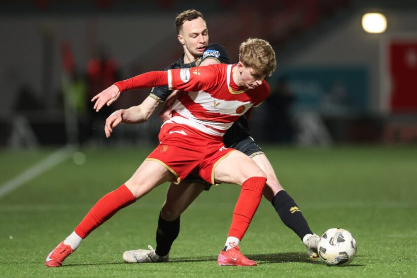 Match-winner Stuart McKinstry holds of Dunfermline defender Chris Hamilton.