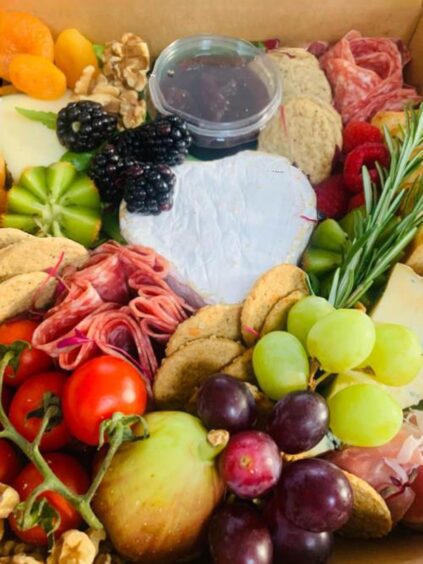 box filled with cheese, cured meats and fruits 