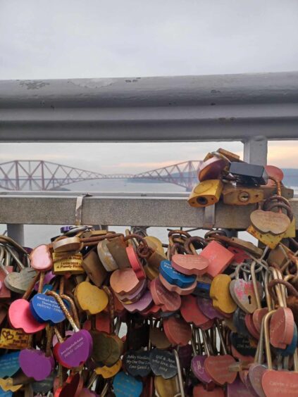 Image shows: the love locks on the Forth Road Bridge, looking through the railings to the Forth Bridge. For Forth Bridges Trail feature.