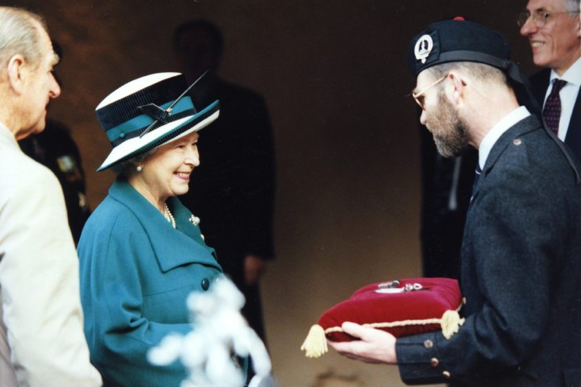 an official presents the keys to The Queen on a red cushion 