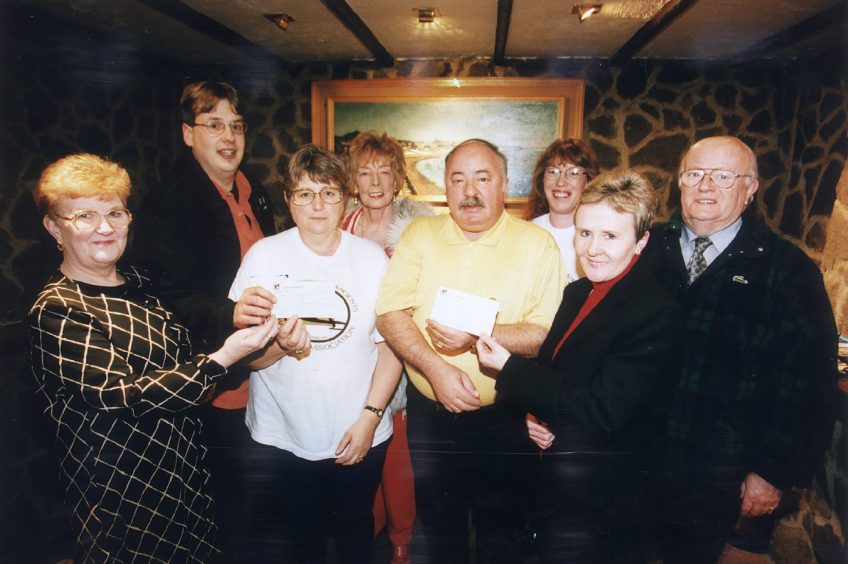 The late John Black hands over a cheque to representatives of Caring for Kids in 1999.