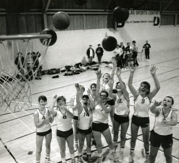 a group of women cheer as someone takes a shot