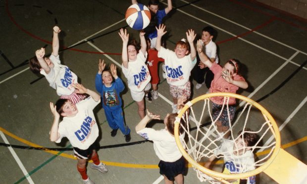 youngsters compete for the ball under the basket during a basketball camp held at St John's High School in Dundee in November 1990