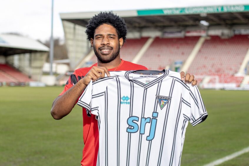 New loan signing Andre Raymond holds up a Dunfermline Athletic top.