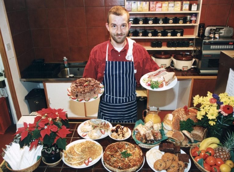 Richard Hudson with plates bearing some of his goodies, like sandwiches, cakes and biscuits