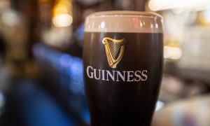 A pint of Guinness sitting on a bar in a pub