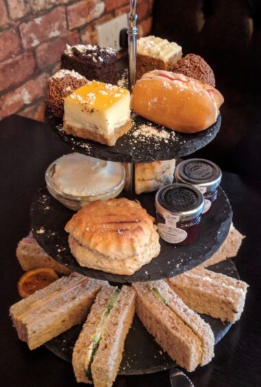 Finger sandwiches, scones and jam, and cakes make up the afternoon tea platter.