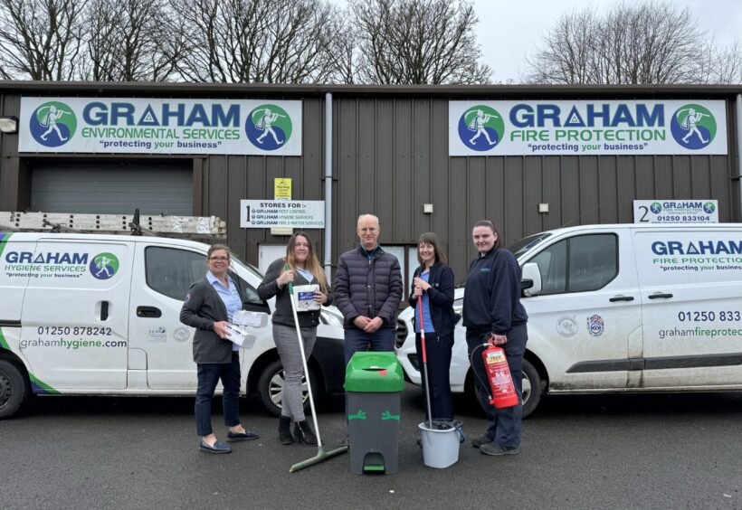 Group of people with cleaning equipment in front of Graham Environmental Services building in Blairgowrie