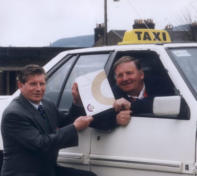 Councillor Ian Wyles presented taxi driver John Duncan, who is sitting in his taxi, with his certificate for completing an initiative course which focused on customer care.