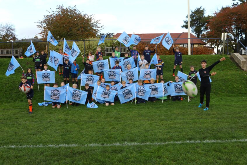 The kids wave Glasgow Warriors flags