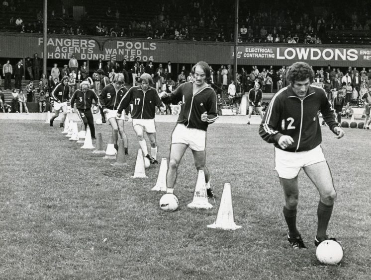 Dundee players dribble through cones at the open day training session