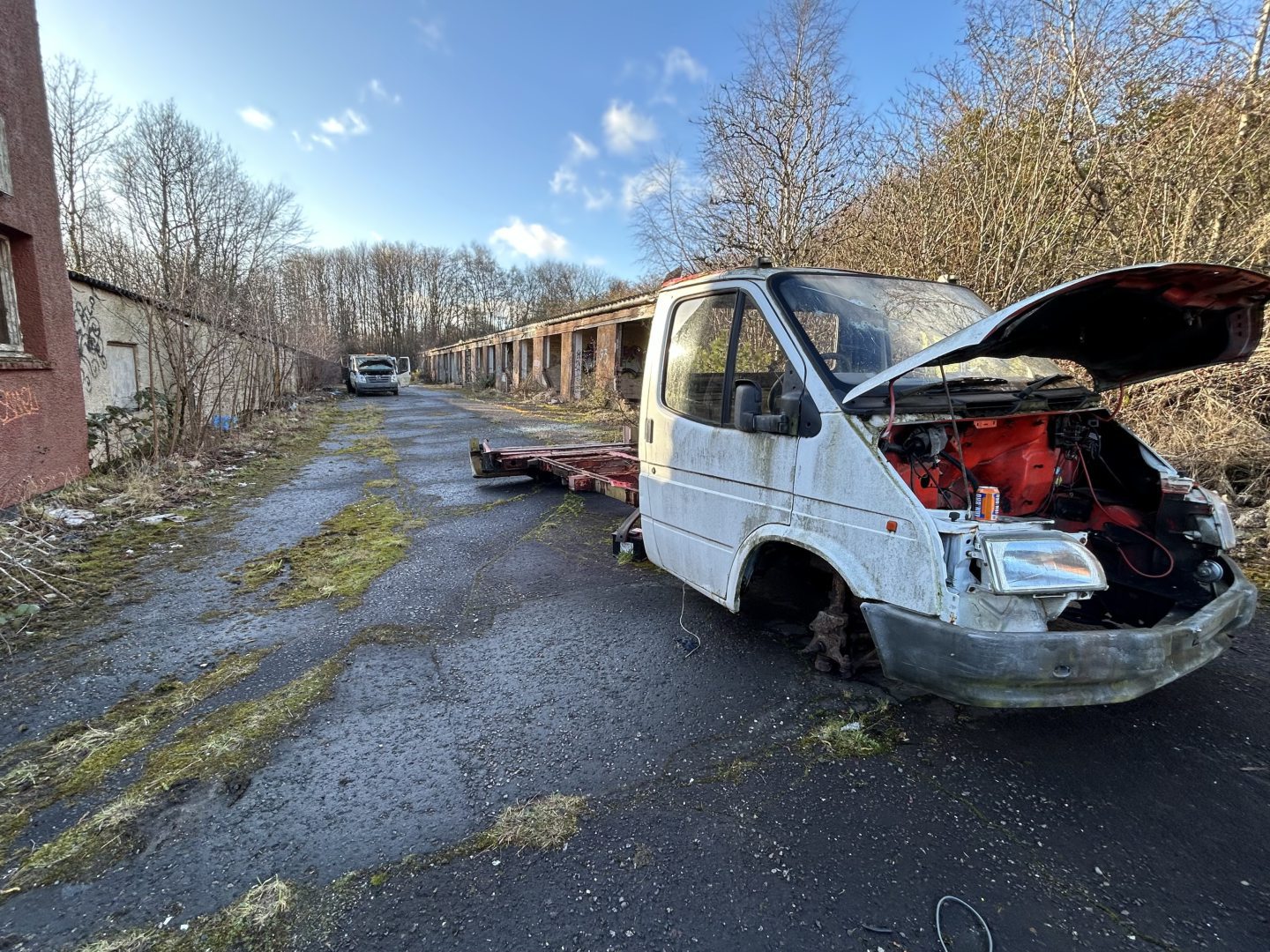 Abandoned vehicles litter the site.