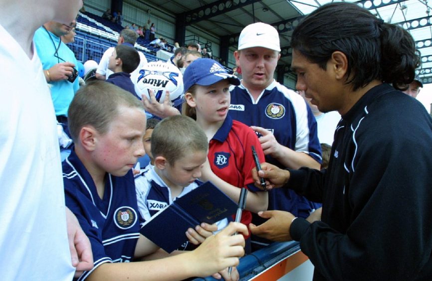 Fabian Caballero signs autographs for fans in the Dens Park stand