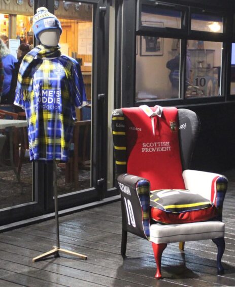 Traditional arm chair upholstered with variety of rugby shirts