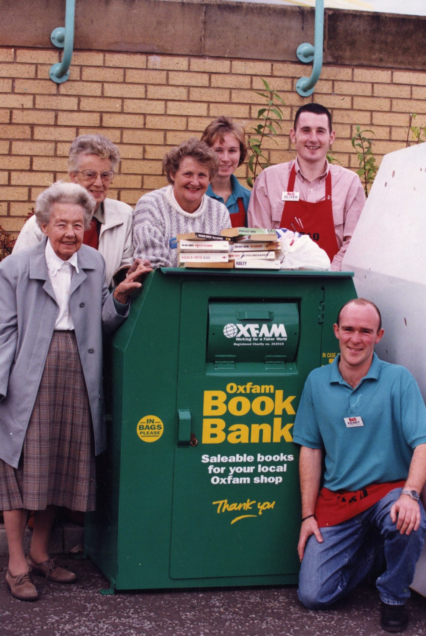 A group of people pose for a picture next to the book bank