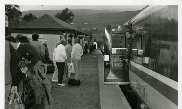 Passengers stand on the platform at Crianlarich after being ejected from their train due to derailment. Image: DC Thomson