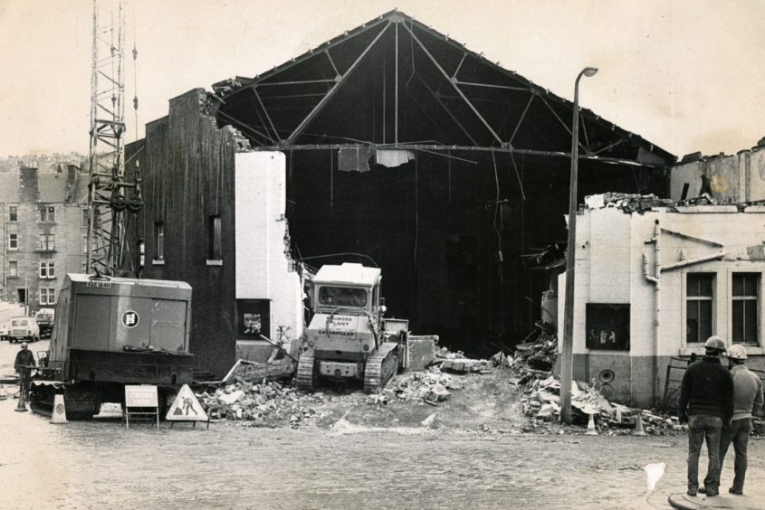 workmen and digger on site as demolition of the Forest Park Cinema takes place in February 1984.