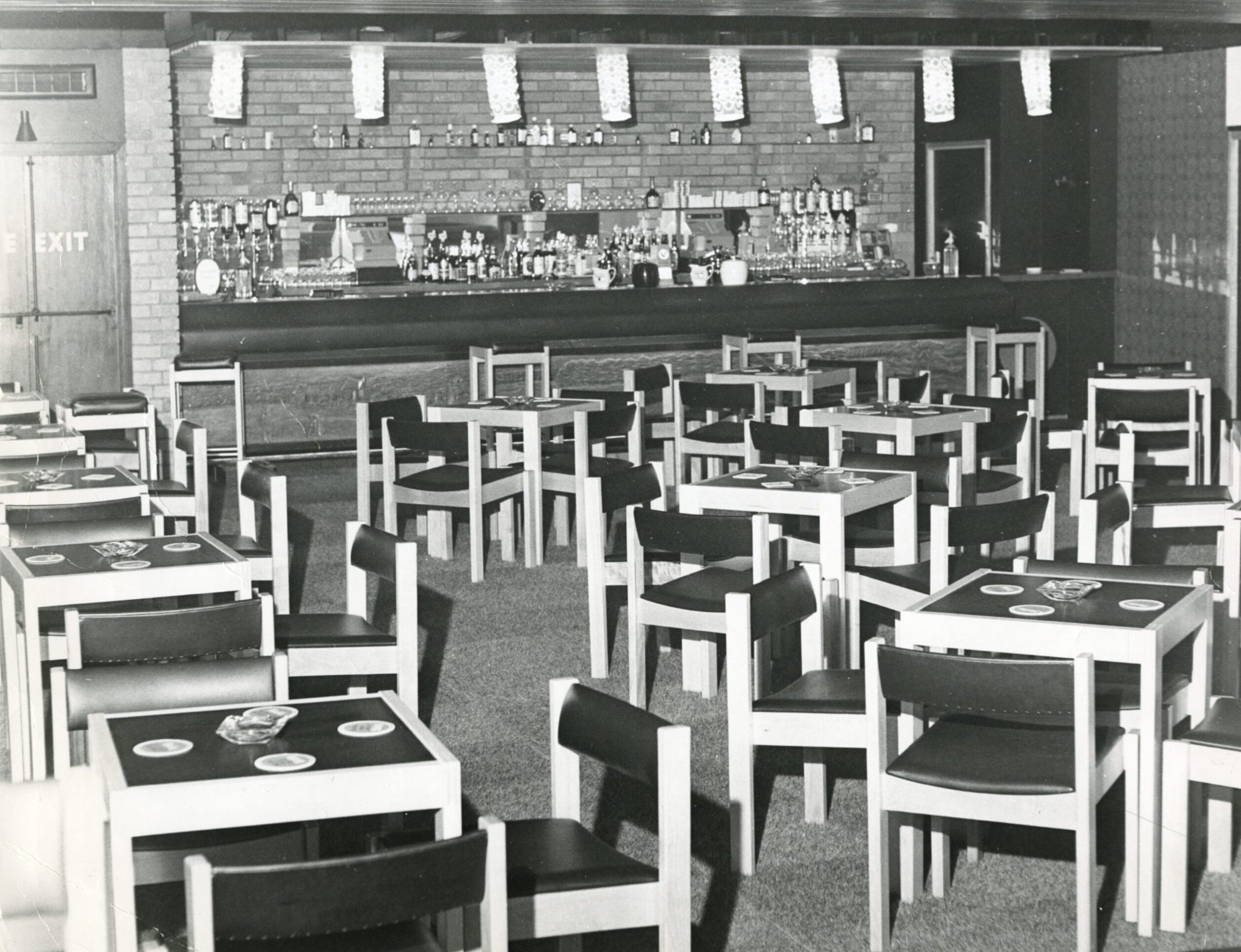 tables and chairs and the bar inside The Fairway Bar in Ardler, Dundee, in 1969