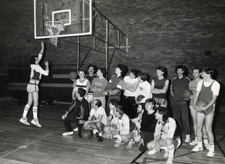 people watch as Brian Jenkins demonstrates how to do a layup