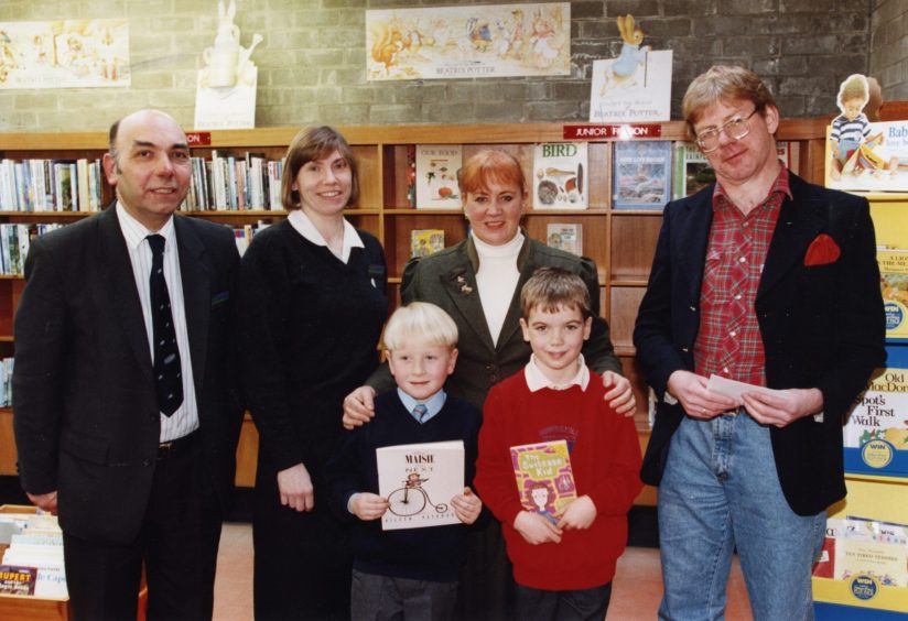 two young competition winners are presented with their prizes