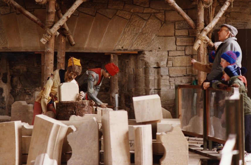 Tourists watching the stonemasons at work during restoration work at the Great Hall at Stirling Castle in October 1994.