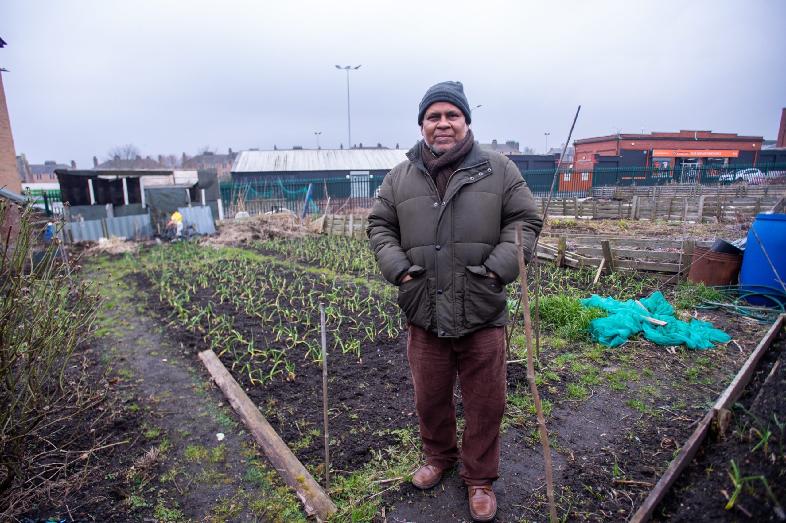 Jalal Uddin and the garlic he is growing on his allotment. 