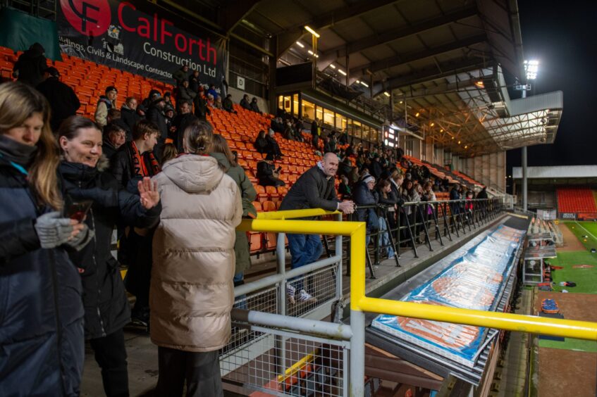 Dundee United fans shuffle in to take their seats.