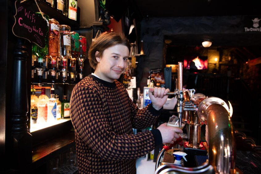 Barman Lawrie Welsh pours a drink at The Creepy Wee Pub in Dunfermline.