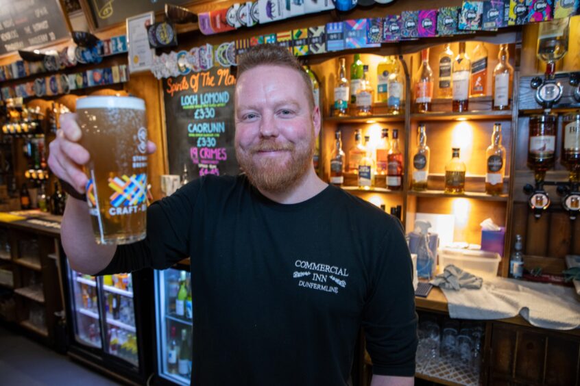 Commercial Inn publican Andy Black raises a pint to the camera