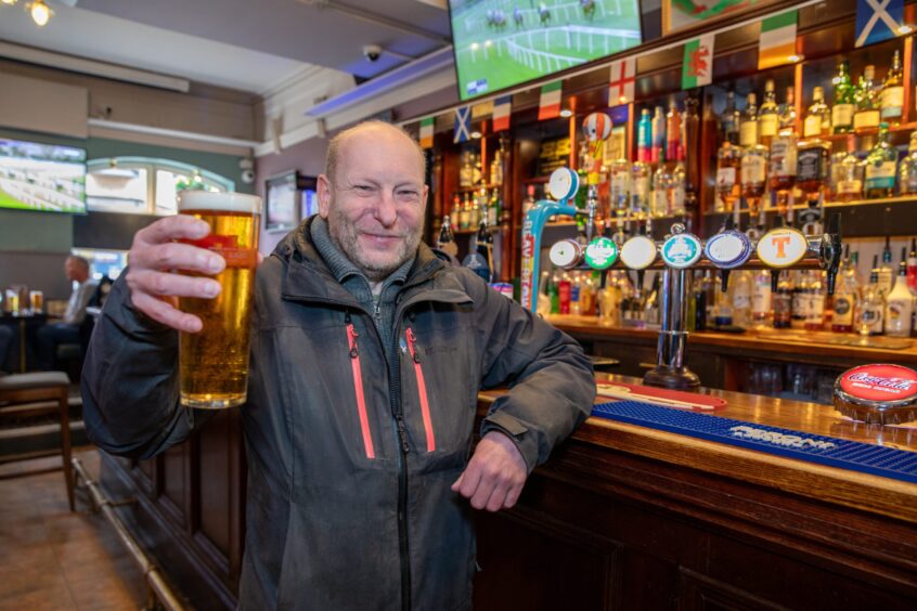 Alan Marshall, raising his glass to the camera, is one of the regulars at the East Port Bar in Dunfermline.