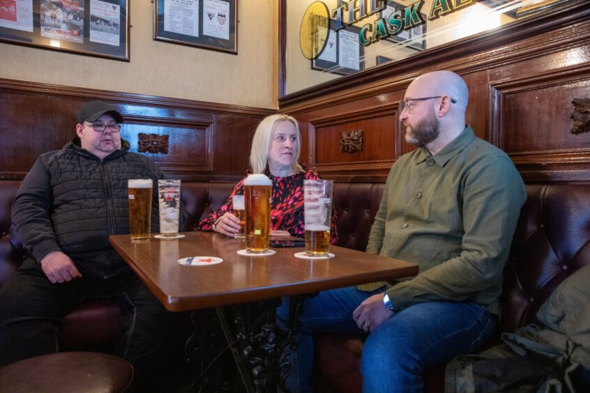 Debbie sits in a booth to talk to Old Inn regulars Craig McTaggart and Mike Dignan