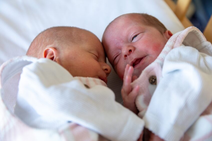 Fife twins Amelia and Celeste lying together in cot