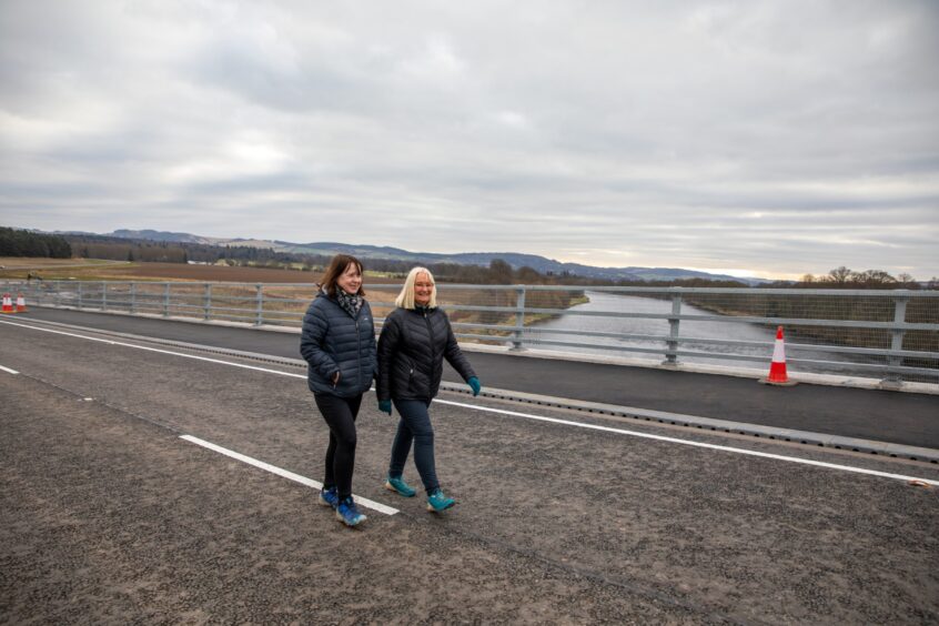 Val Riddell and Morag Ritchie walking across Destiny Bridge with River Tay in background