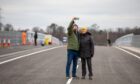 Couple wrapped up in anoraks posing for selfie on Destiny Bridge