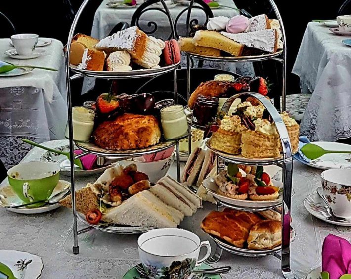 Tiered afternoon tea dishes stacked with sandwiches and sweet treats, laid out on a table at Mary's Kitchen.