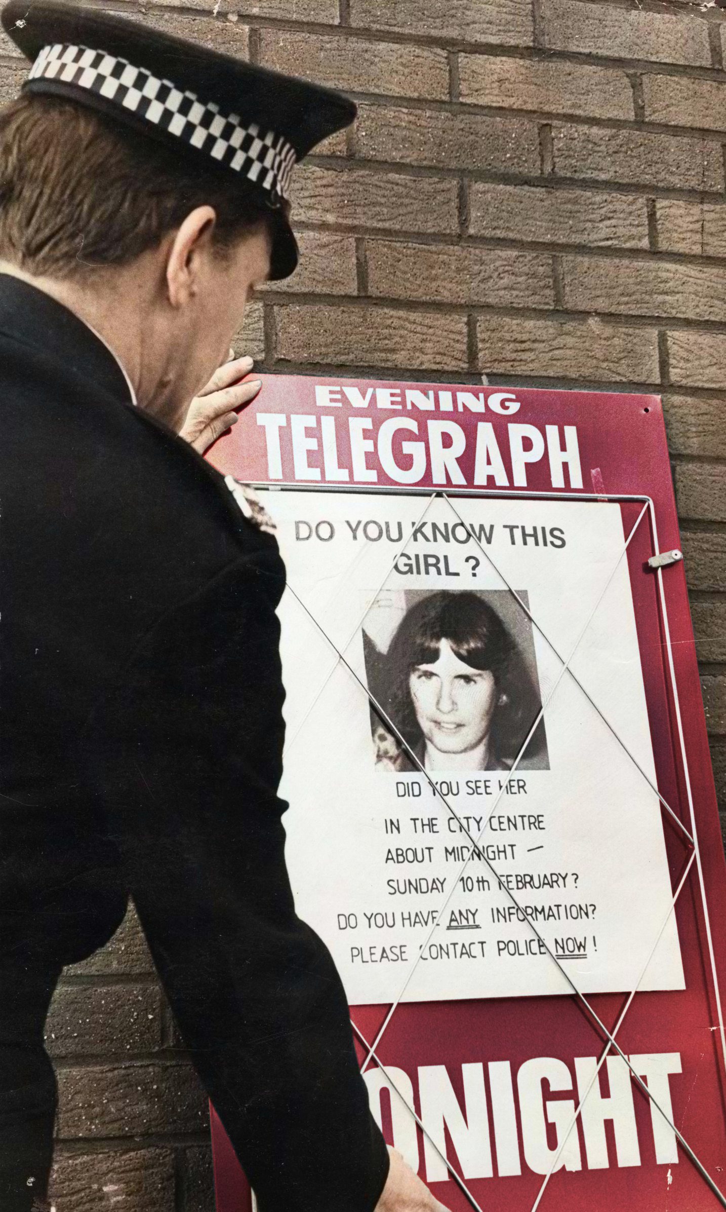 A police officer with a missing person poster featuring a picture of Elizabeth McCabe in Dundee in 1980. 