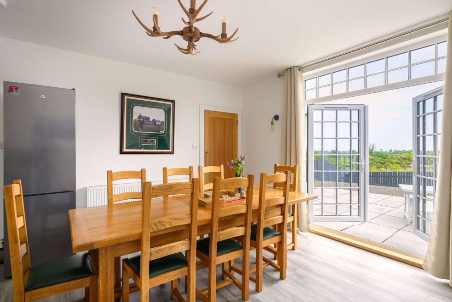 Family dining area with french windows leading out to a patio.