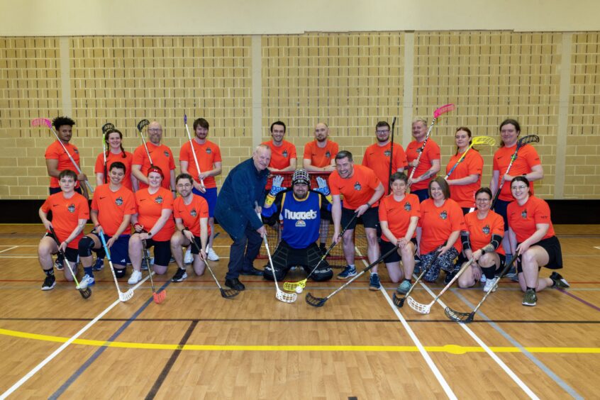 Pete Wishart posing with members of Perth Parrots floorball team on new rink