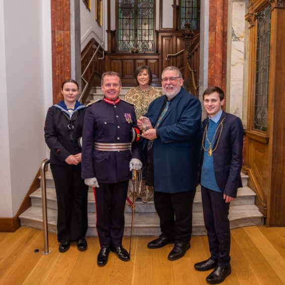 John Watson holding award in group of dignitaries