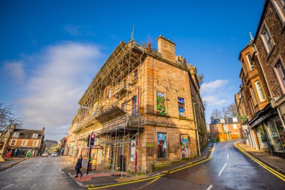 Drummond Arms Htel exterior, with scaffolding, biarded windows and weeds growing from masonry