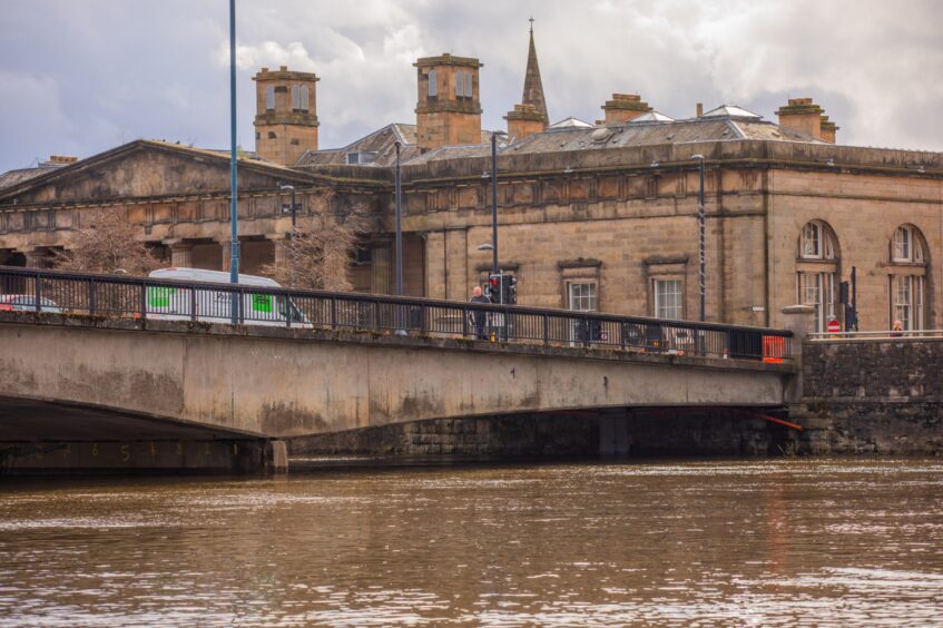 Queen's Bridge with vans and cars passing over and high level on River Tay beneath