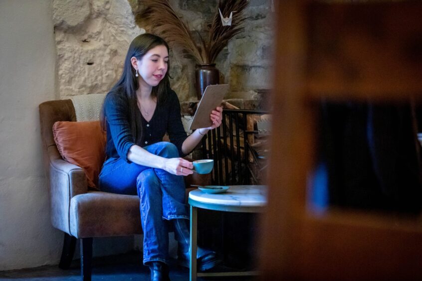 poppy watson enjoying a coffee in prost cafe in abbot house in dunfermline 