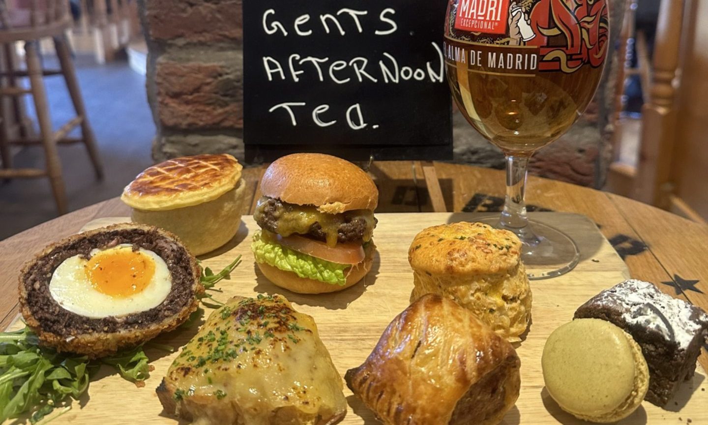 A selection of pies and scotch eggs next to a pint of beer.