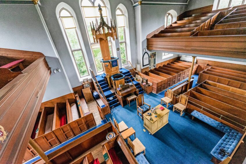 Church interior, showing rows of pews over two levels