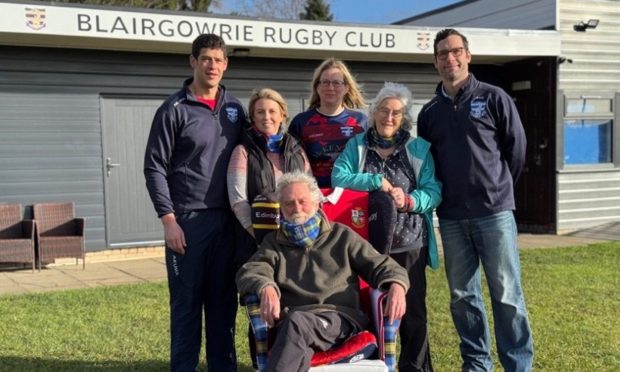 Len Seal seated on chair surrounded by wife and daughter and others associated with Blairgowrie rugby club