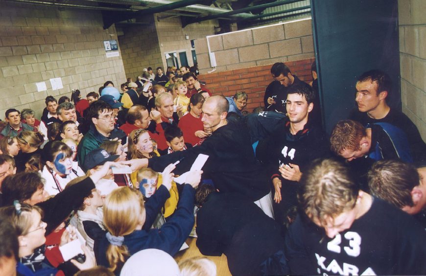 fans inside the stadium at a busy signing session with Dundee FC players