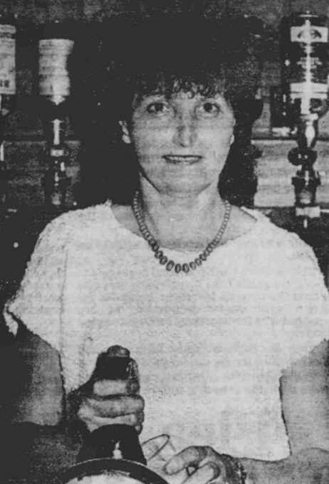 a black and white picture showing Martha Sulley behind the bar